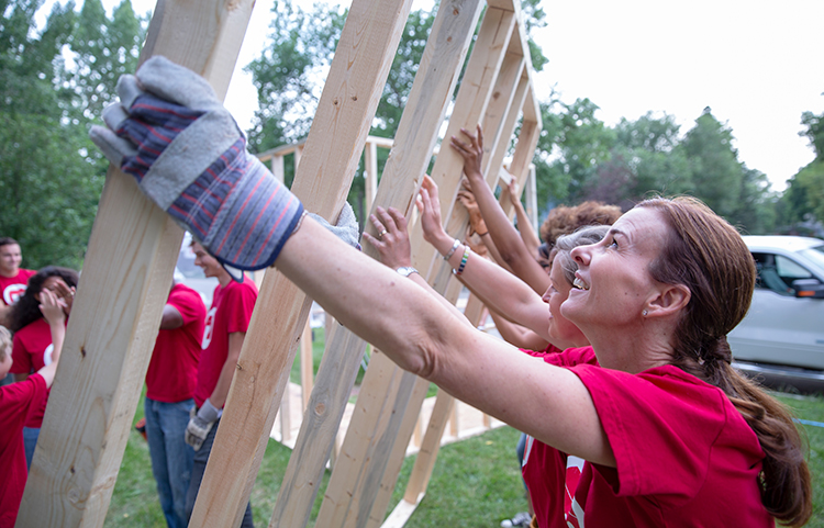 People helping build a wood frame for a house